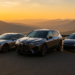 High-resolution digital photograph captures three top electric vehicles parked at a scenic overlook during sunset, with rolling hills in the background.