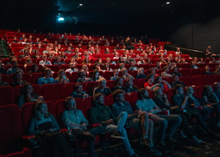 Moviegoers enjoying April 2025 new releases in theaters and on streaming platforms.